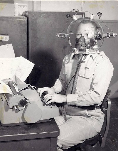 some kind of weird helmet that provides oxygen to an office worker